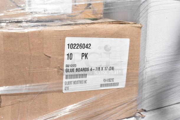 Cardboard box labeled "10226042 Glue Boards, 4-7/8 x 17," wrapped in plastic, showing 10 packs by Gilbert Industries.