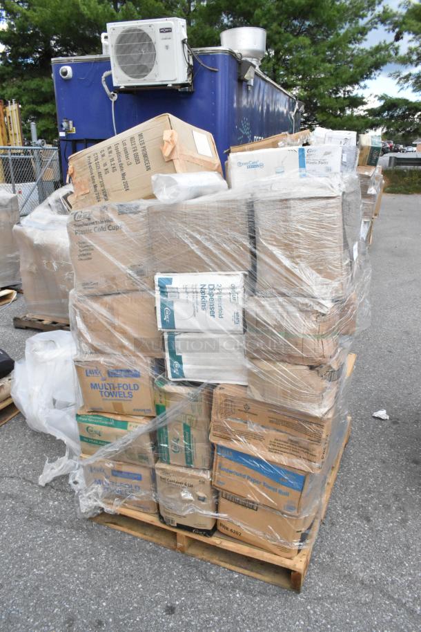 Pallet of boxed items including cold cups, napkins, gloves, trash bags, and towels. Some boxes show signs of wear.