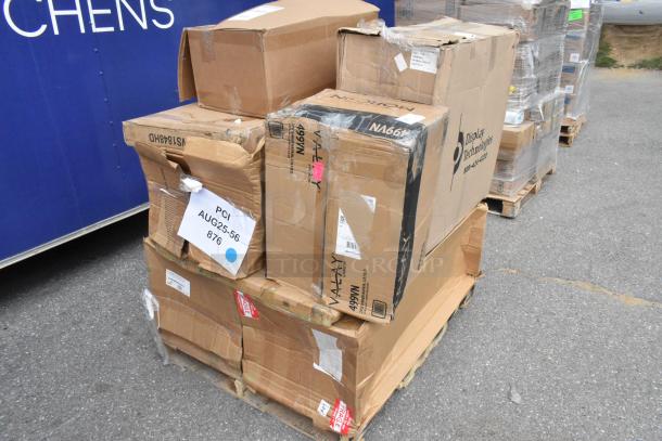 Boxes of new scratch and dent items, including an organizer and tabletop, on a pallet with visible labels and packaging damage.