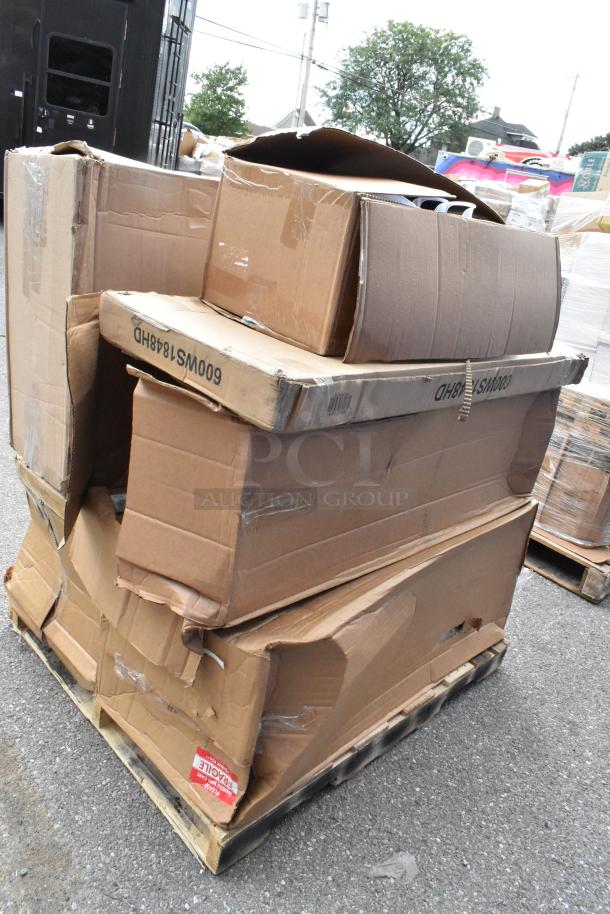 Eight new scratch and dent items on pallet, including organizer and tabletop, in damaged boxes. Handle with care label visible.