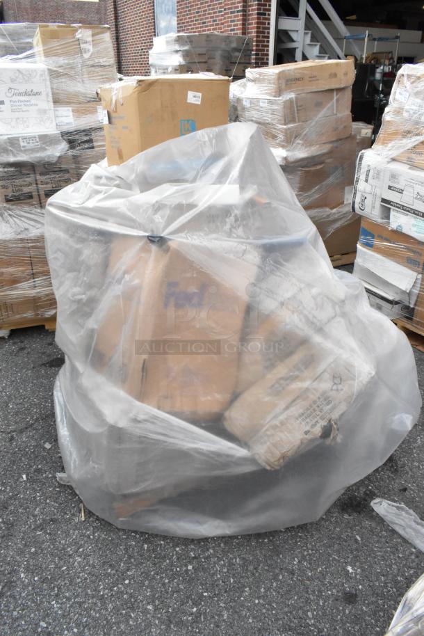 Bulk items covered in plastic, including boxes with visible markings. Mixed items, scratch and dent condition. Auction lot.