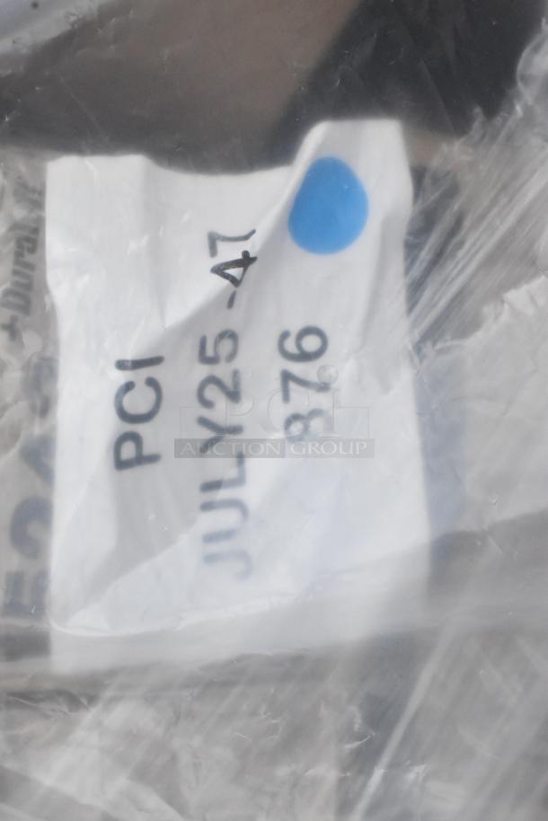 Plastic-wrapped item with visible tag marked "PCI JULY25-47 876" and a blue dot, part of a mixed lot auction.