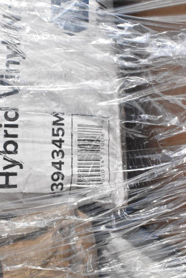 Plastic-wrapped pallet containing assorted brand new scratch and dent items, including towels, hot cups, gloves, napkins, and foil.