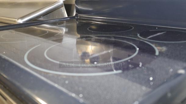 Kenmore stove model C648433, features a black glass cooktop with four burner outlines, in good used condition.