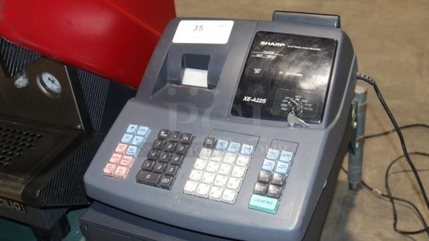 Sharp XE-A22S cash register, 14x14x12 inches, with keypad and display, includes key, good condition for auction.