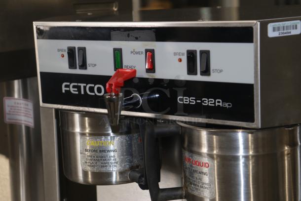 "Used Fetco CBS-32Aap stainless dual coffee brewer, 120/208-240V. Features brew and stop switches, caution labels visible."