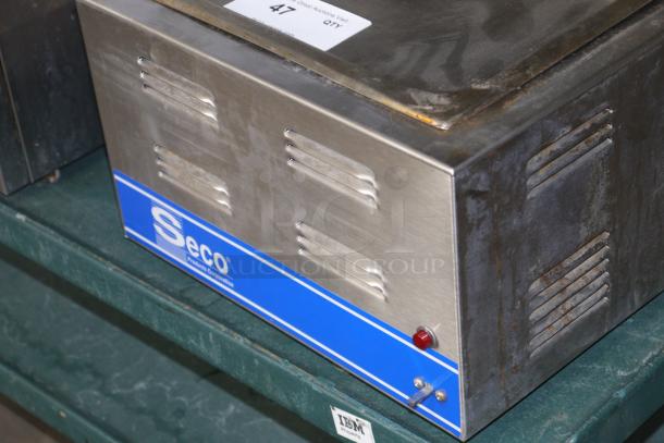 SESCO CW-1200 metal equipment with blue label, ventilation slots, and switch. Shows signs of wear, placed on a shelf.