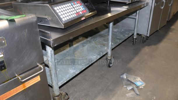 61" stainless-steel counter with casters, ideal for baking or cooking. Features sturdy metal construction and spacious lower shelf.