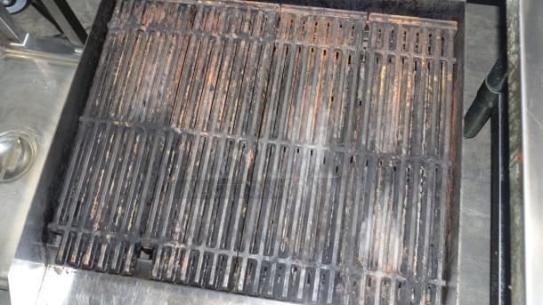 Avantco 2 burner gas grill with cast iron grates, showing signs of use with rust and wear, suitable for commercial use.