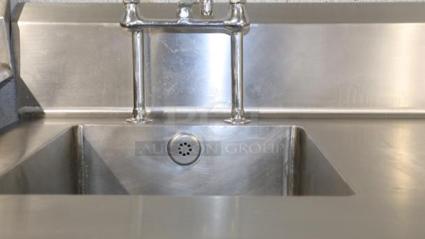 101.5" stainless-steel counter with built-in sink, faucet, and smooth surface for baking, cooking, or storage.