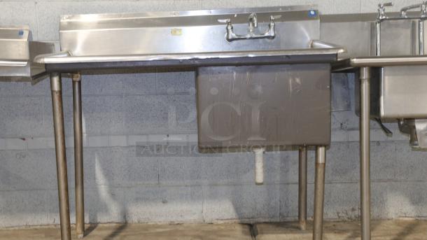 50" stainless-steel counter with sink, ideal for baking and cooking. Features dual faucets and sturdy support legs.