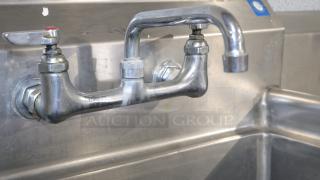 Stainless steel baking counter with faucet, 50" long, durable for cooking or storage, slight wear visible.