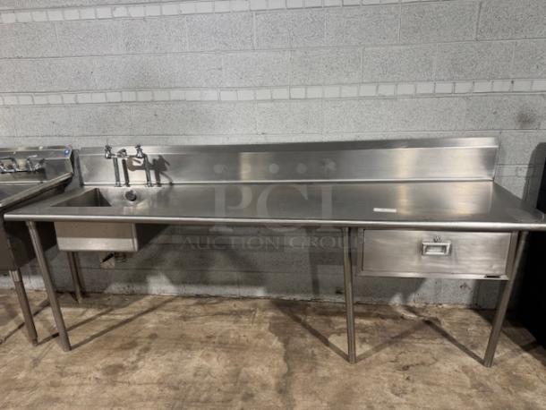 101.5" stainless-steel counter with integrated sink and drawer, ideal for baking or cooking. Features a backsplash, sturdy legs. Excellent condition.