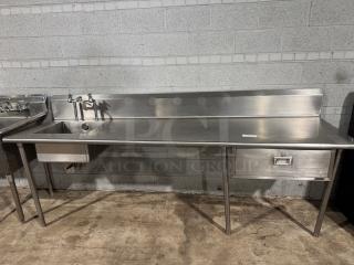 101.5" stainless-steel counter with integrated sink and drawer, ideal for baking or cooking. Features a backsplash, sturdy legs. Excellent condition.