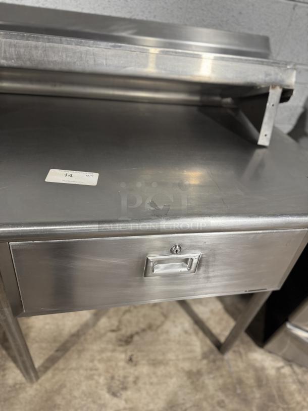 Stainless steel counter, 101.5", with drawer for baking or storage. Minor surface wear. Auction tag: 14 from PCAuction.com.