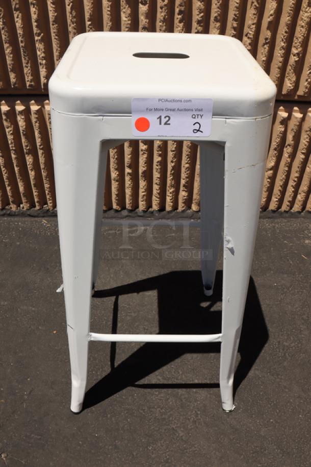 Lancaster Table & Seating Alloy Pearl White outdoor backless barstool, model 164BMBKLSWHT, showing minor scratches.