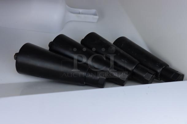 Four black conical objects on a white surface, resembling ice machine components or accessories.