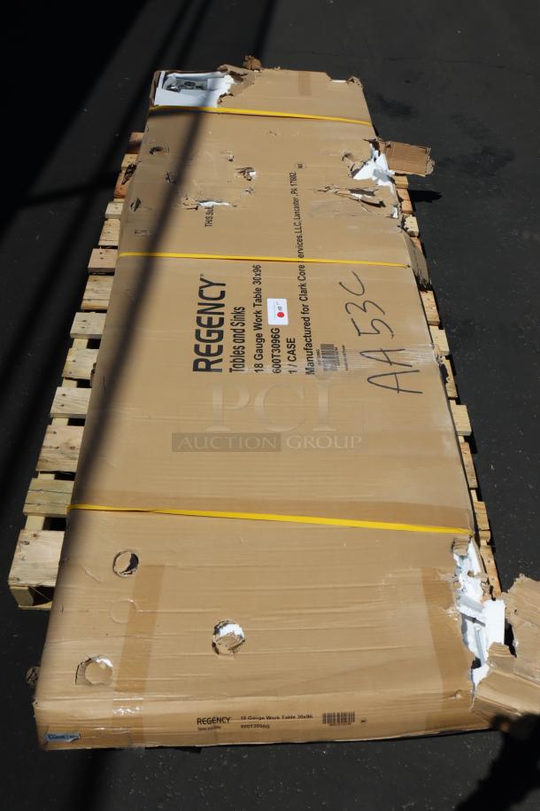 Regency 600T3096G stainless steel work table in damaged box on pallet. Box may be missing parts; includes scratches/dents.