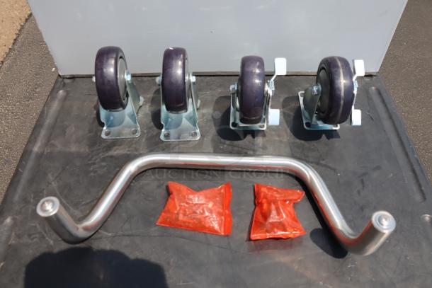 New Regency utility cart parts; four wheels, handle, and two red packages on black surface. Model 600CT5S1624E.