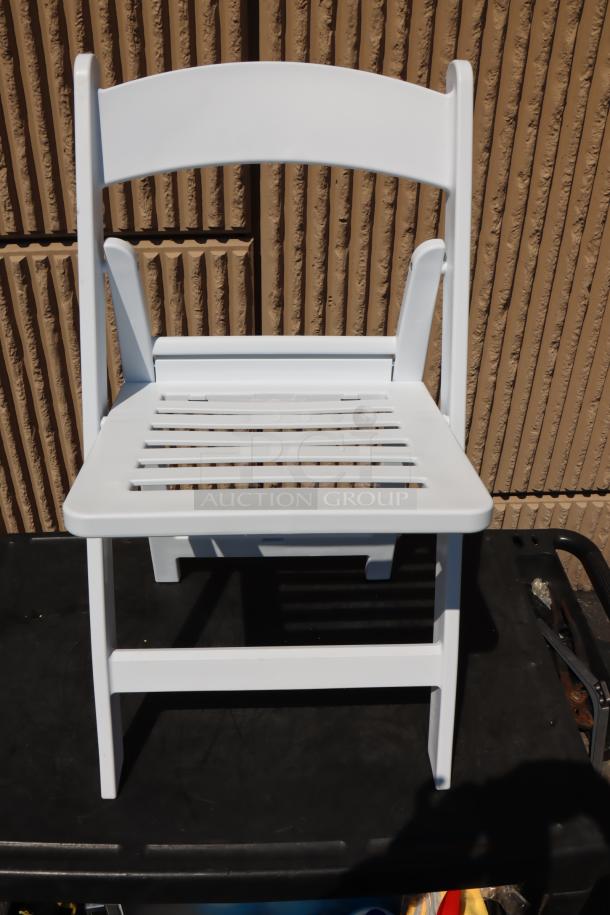 White resin folding chair with slatted seat by Lancaster Table & Seating, model 427FCRSLTWHT, new condition.