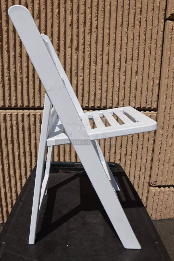 White resin folding chair with slatted seat by Lancaster Table & Seating, model 427FCRSLTWHT, new condition.