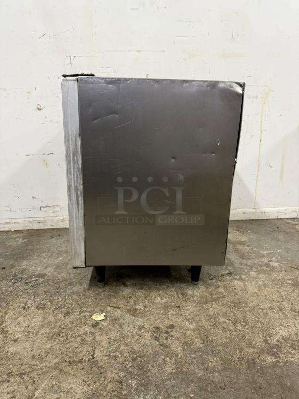 Silver King SKTTR7 undercounter refrigerator, stainless steel, visible scratches and dents, four sturdy legs.