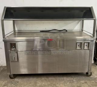 Stainless steel hot food merchandiser with glass display, control panel, and storage, on wheels. Good condition.