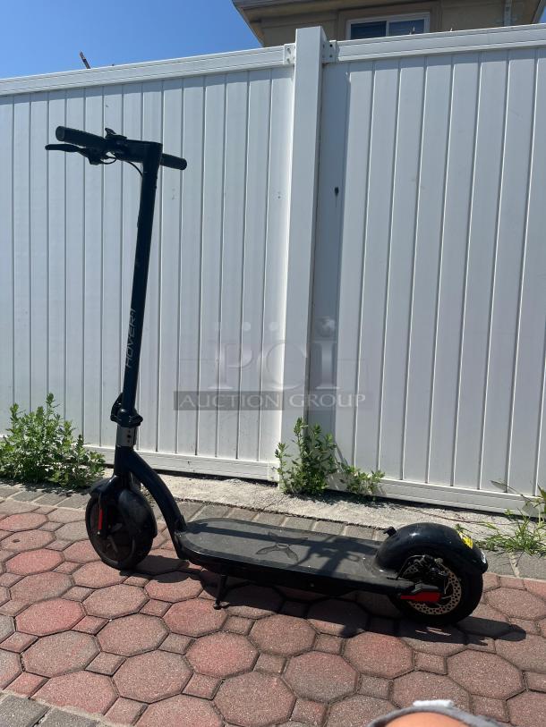 Hover-1 black electric scooter, self-balancing, LED, 18 mph, UL 2272 certified, in used condition on brick pavement.