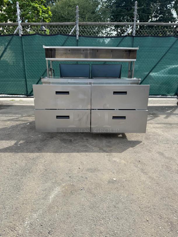 Delfield D4464NP 4 Drawer Mega Top Refrigerated Sandwich Prep Table, stainless steel finish, 5" casters, outdoor setting.