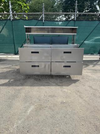 Delfield D4464NP 4 Drawer Mega Top Refrigerated Sandwich Prep Table, stainless steel finish, 5" casters, outdoor setting.
