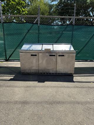 Delfield Model 4472M-30M-A1, 72in stainless steel 3-door mega top refrigerated sandwich prep station, outdoor setting.