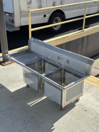 Regency 57" 16-gauge stainless steel two-compartment commercial sink with left drainboard, model 600S2171718L, new condition.