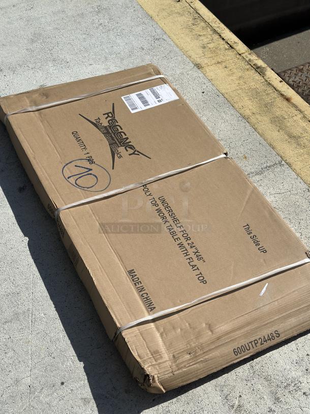 Regency 18 Gauge Stainless Steel Adjustable Shelf, model 600UTP2448S, packaged in a box, minor wear visible, for 24"x48" work tables.