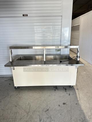 USED Shelleyglas by Delfield serving station with stainless steel top, undershelf, and caster wheels. Some surface wear.