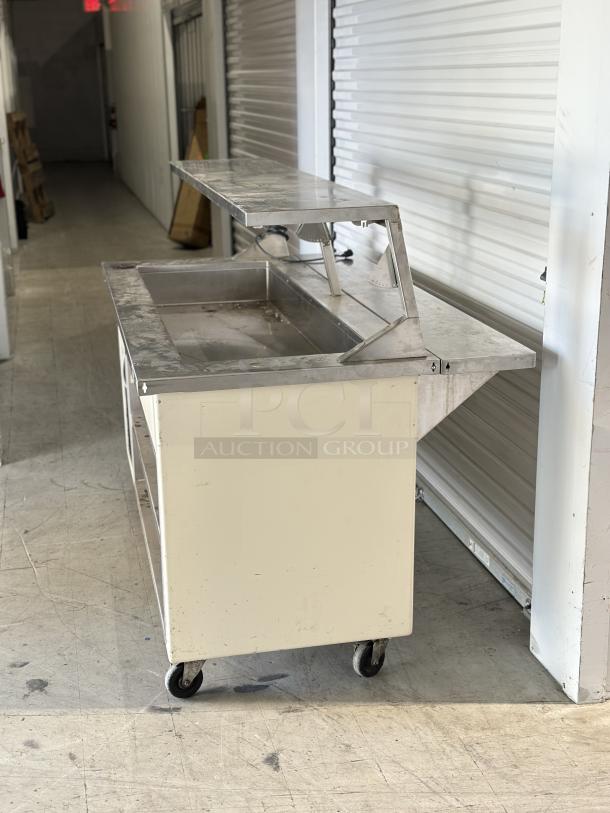 Shelleyglas by Delfield serving station, used, with undershelf and stainless steel surface. Mounted on wheels for mobility.