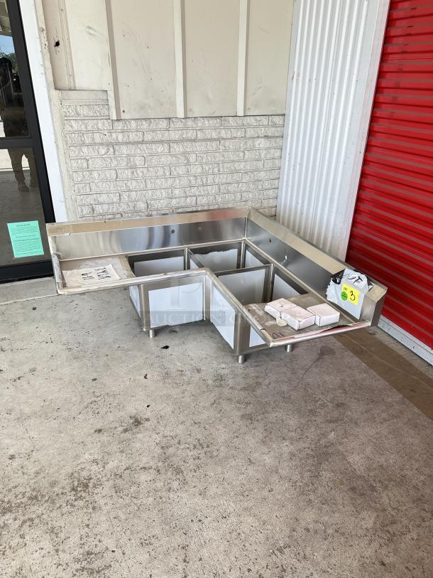 Regency 57" three-compartment stainless steel corner sink with drainboards. Model 600S31620CC. Brand new, scratch and dent.