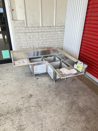 Regency 57" three-compartment stainless steel corner sink with drainboards. Model 600S31620CC. Brand new, scratch and dent.