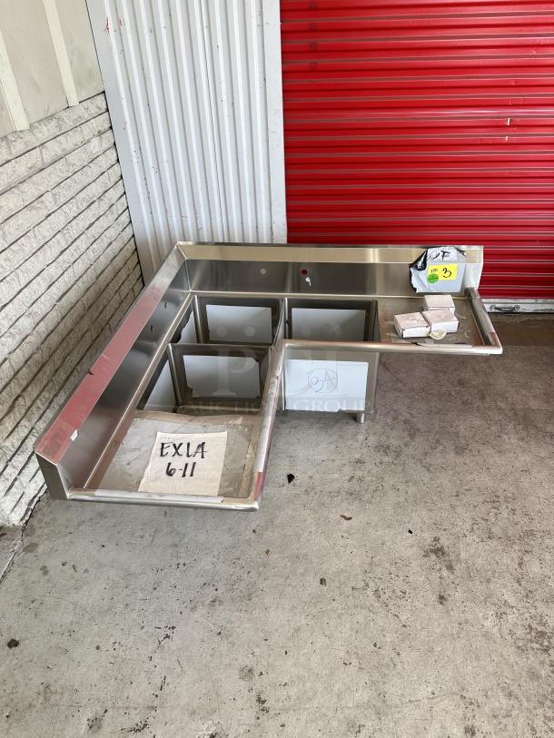 Regency 57" stainless steel corner sink, model 600S31620CC. New condition, three 16"x20"x14" bowls, two drainboards.