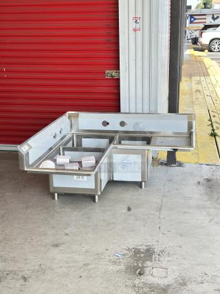 Brand new Regency 57" stainless steel corner sink, model 600S31620C, with three compartments and two drainboards.