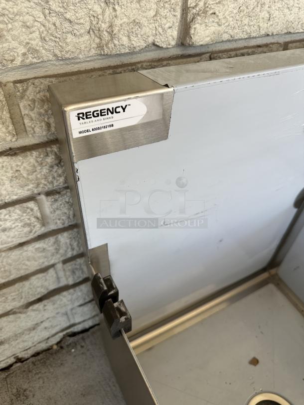 Brand new Regency two-compartment utility sink, model 600S21821SB, with minor scratches. Dimensions: 18" x 21" x 13".