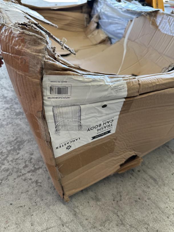 Brand new Lancaster Table & Seating Black Outdoor Trash Can Body, showing scratched and dented packaging. 