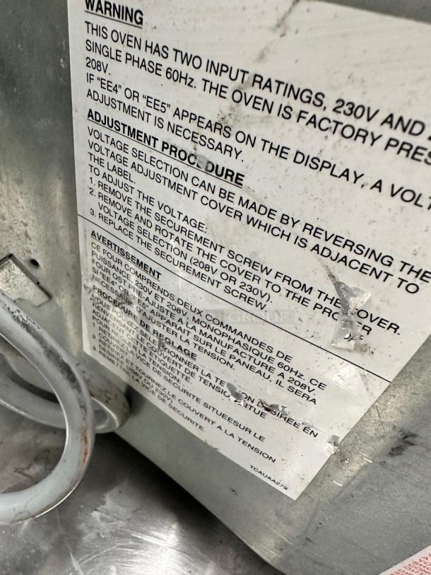 Sharp R-23GT-F commercial microwave, 208/230V, excellent condition, warranty label visible with voltage adjustment instructions.