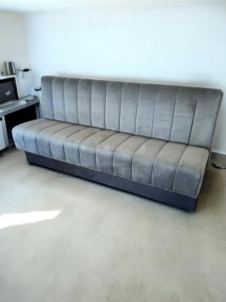 Gray upholstered booth bench, 82" wide, in excellent condition. Vertical tufting, suitable for restaurant use.