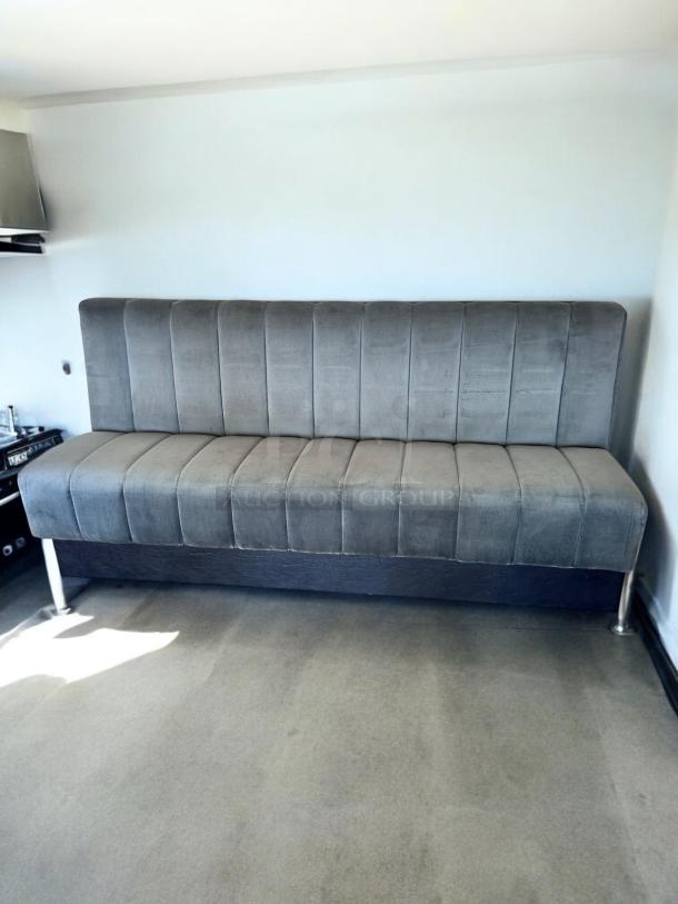 82" wide upholstered restaurant booth in excellent condition, gray fabric, ready for use, shown in a well-lit room.