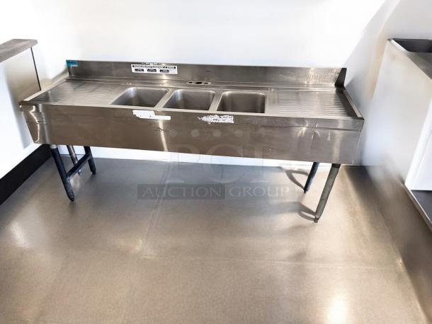 Three-compartment stainless steel bar sink, 72"x24"x35", dual drainboards, excellent condition, fully tested and working.