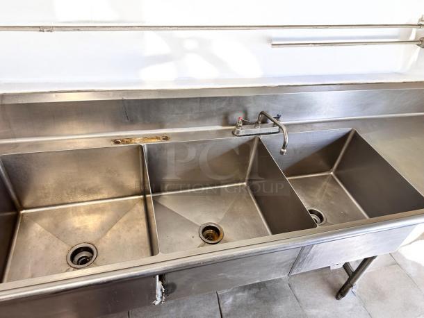 Stainless steel 3-compartment sink with dual drainboards, 132"L x 31"W x 42"H, excellent condition, fully tested.