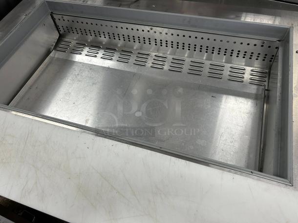 Continental Refrigerator SW48-N-18M prep table interior, showing stainless steel compartment, vents, and chopping board surface.
