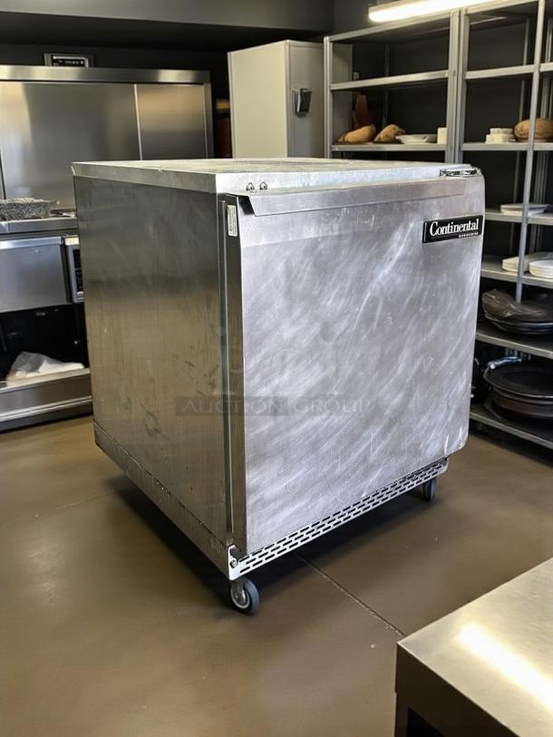 Continental UC27 7.4 cu ft undercounter refrigerator, stainless steel, front breathing, fully tested, on wheels, model label visible.