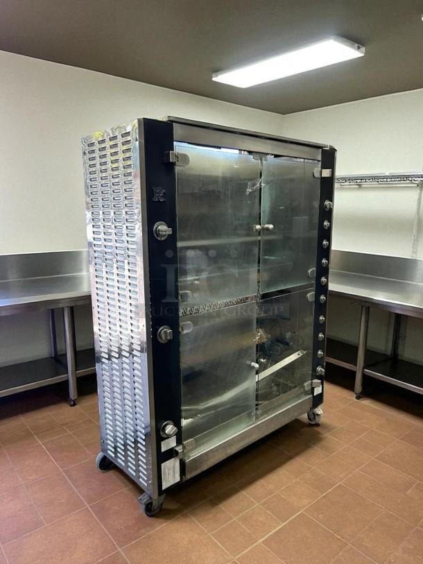 Commercial glass-door warming cabinet with metal sides, on wheels, featuring multiple control knobs, appears in good condition.