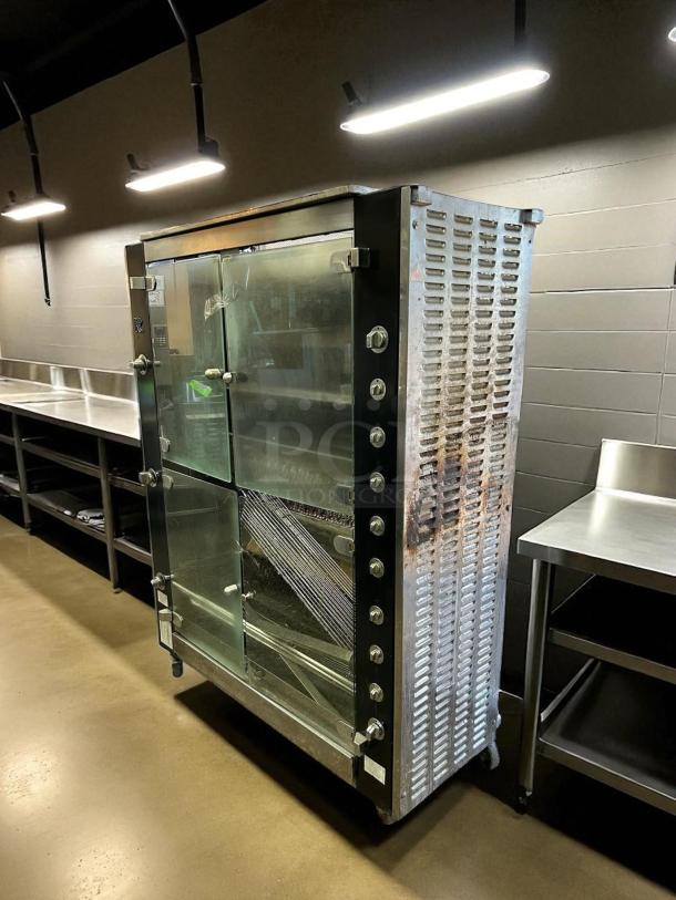 Commercial stainless steel display case with glass doors, metal knobs, and visible shelving. Appears in used condition.